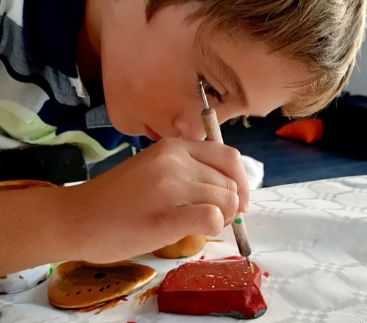 Niño enfocado decorando piedras